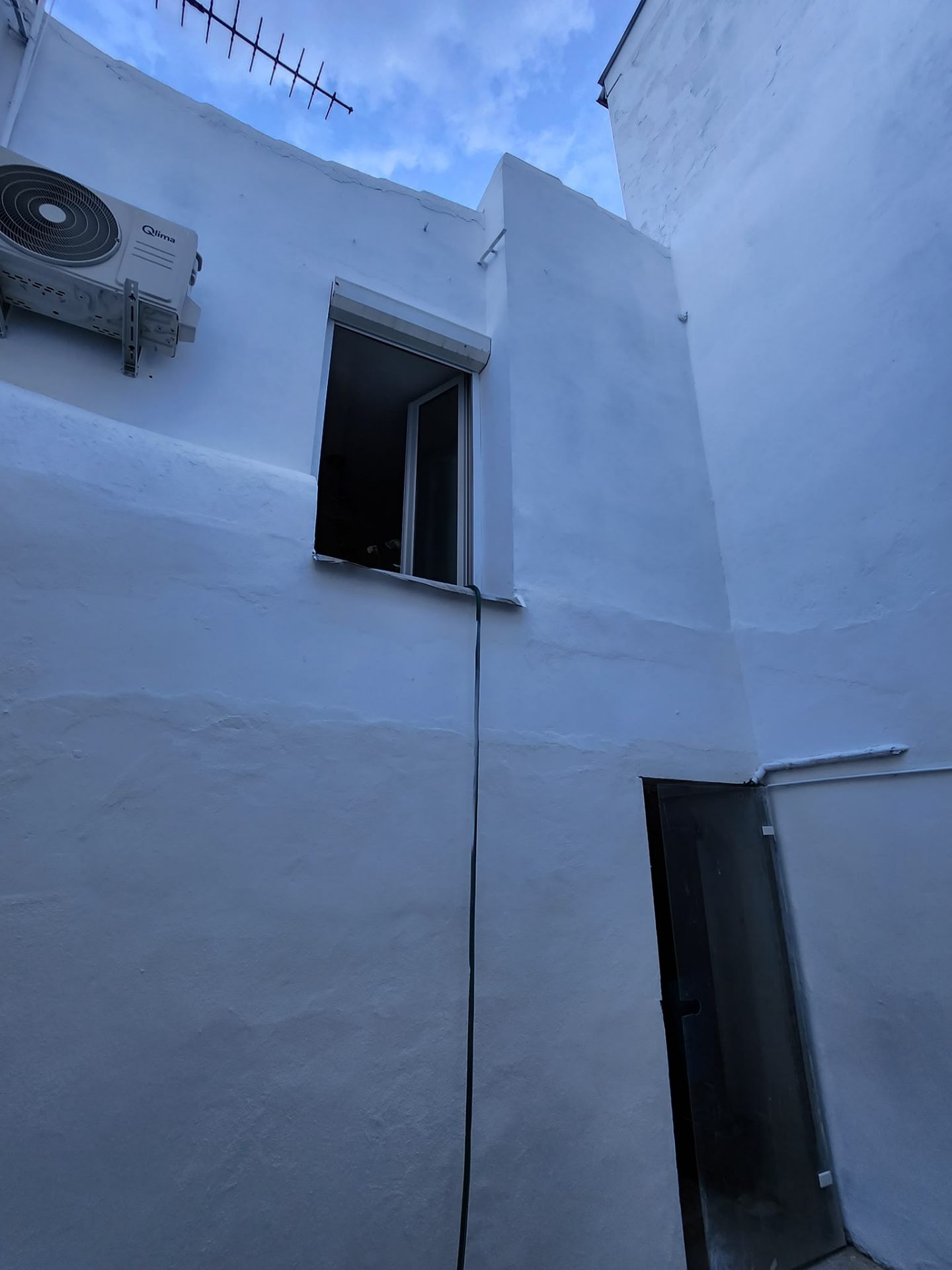 Mur de cour après ravalement, peinture blanche uniforme