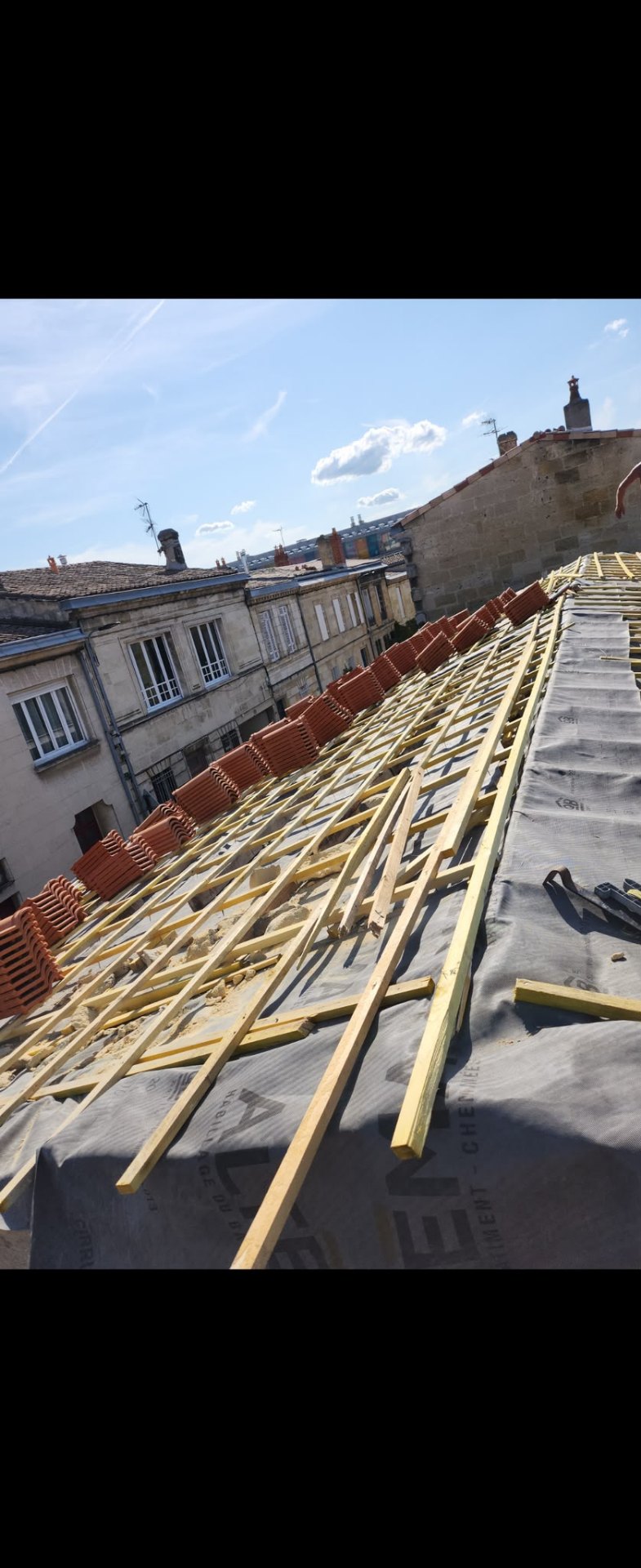 Toiture en cours de réfection avec charpente et tuiles préparées