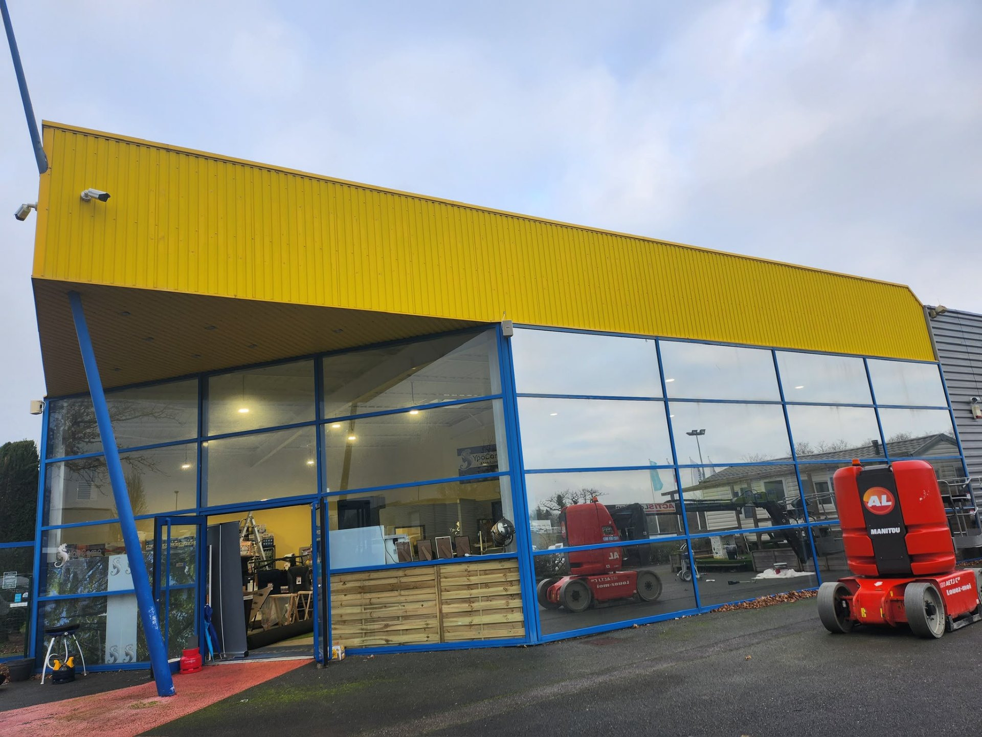 Bardage industriel repeint en jaune et bleu après travaux